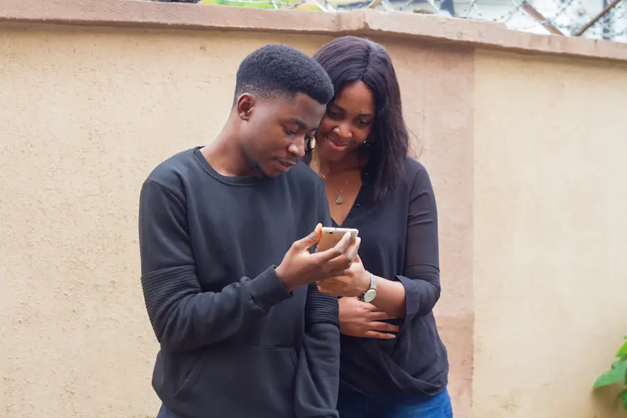 A young man showing his phone to a friend