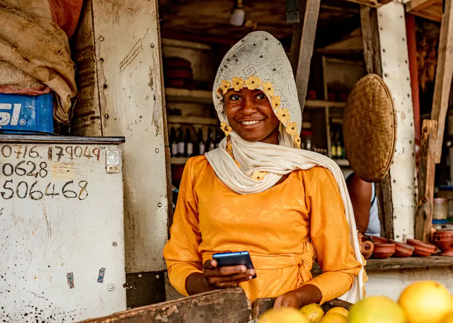 Smiling market seller at her stall, phone in hand